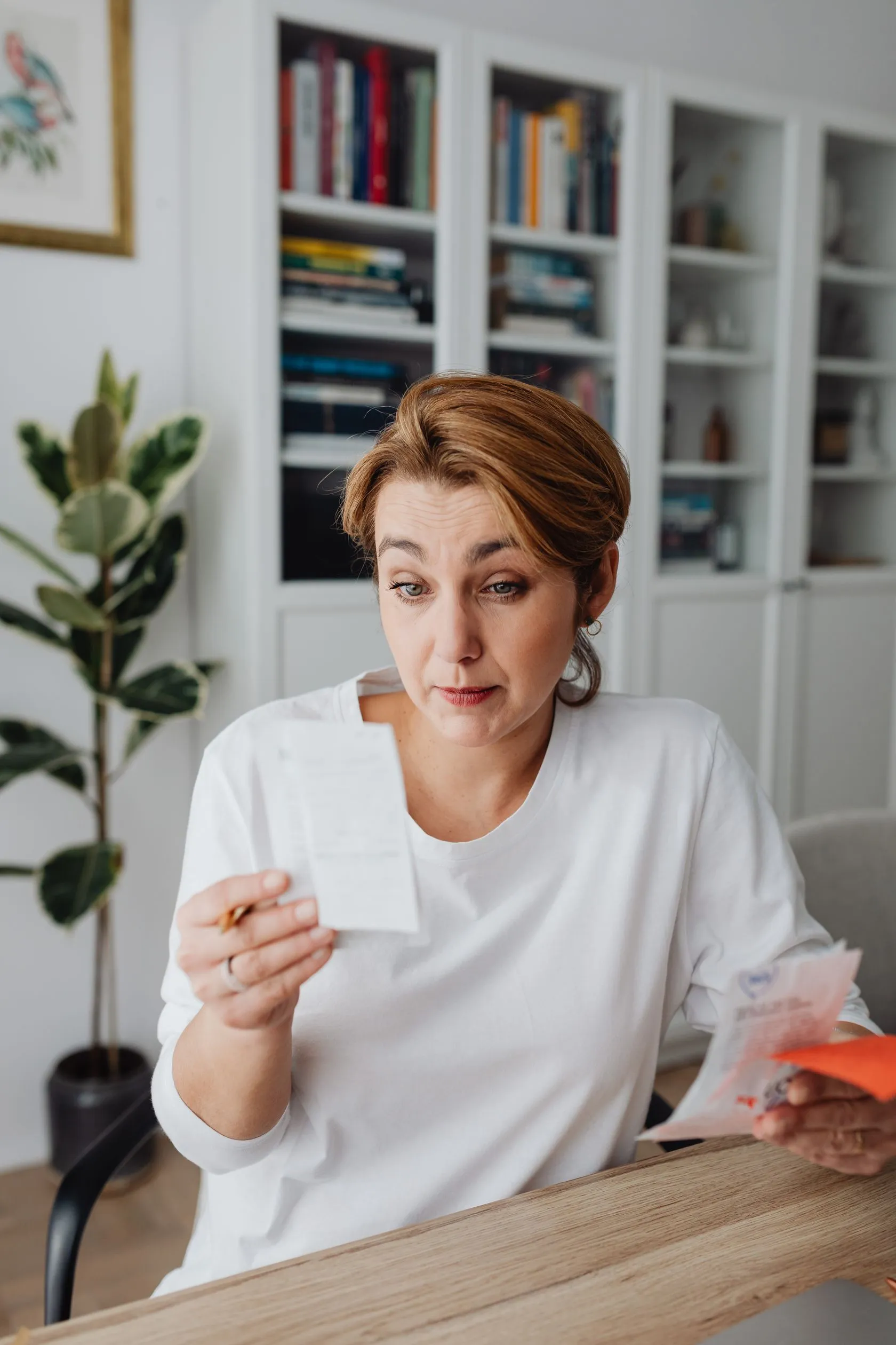 A woman reviews a bill at home, thinking it through.